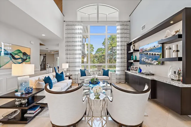 a living room with furniture a flat screen tv and a large window