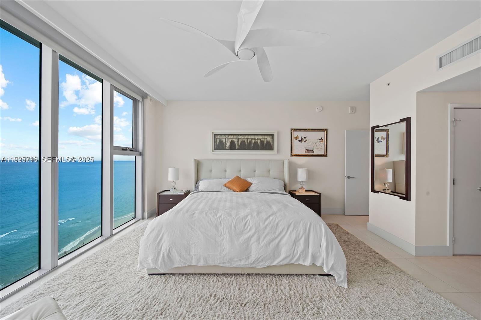 6899 Collins Avenue, Unit 1801 Miami Beach, FL 33141 - Photo 14 of 67 a bedroom with a large bed and a large window