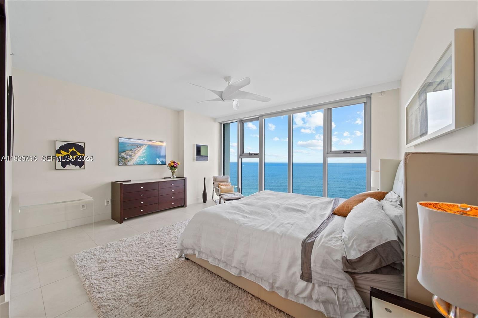 6899 Collins Avenue, Unit 1801 Miami Beach, FL 33141 - Photo 16 of 67 a bedroom with a bed dresser and a large window