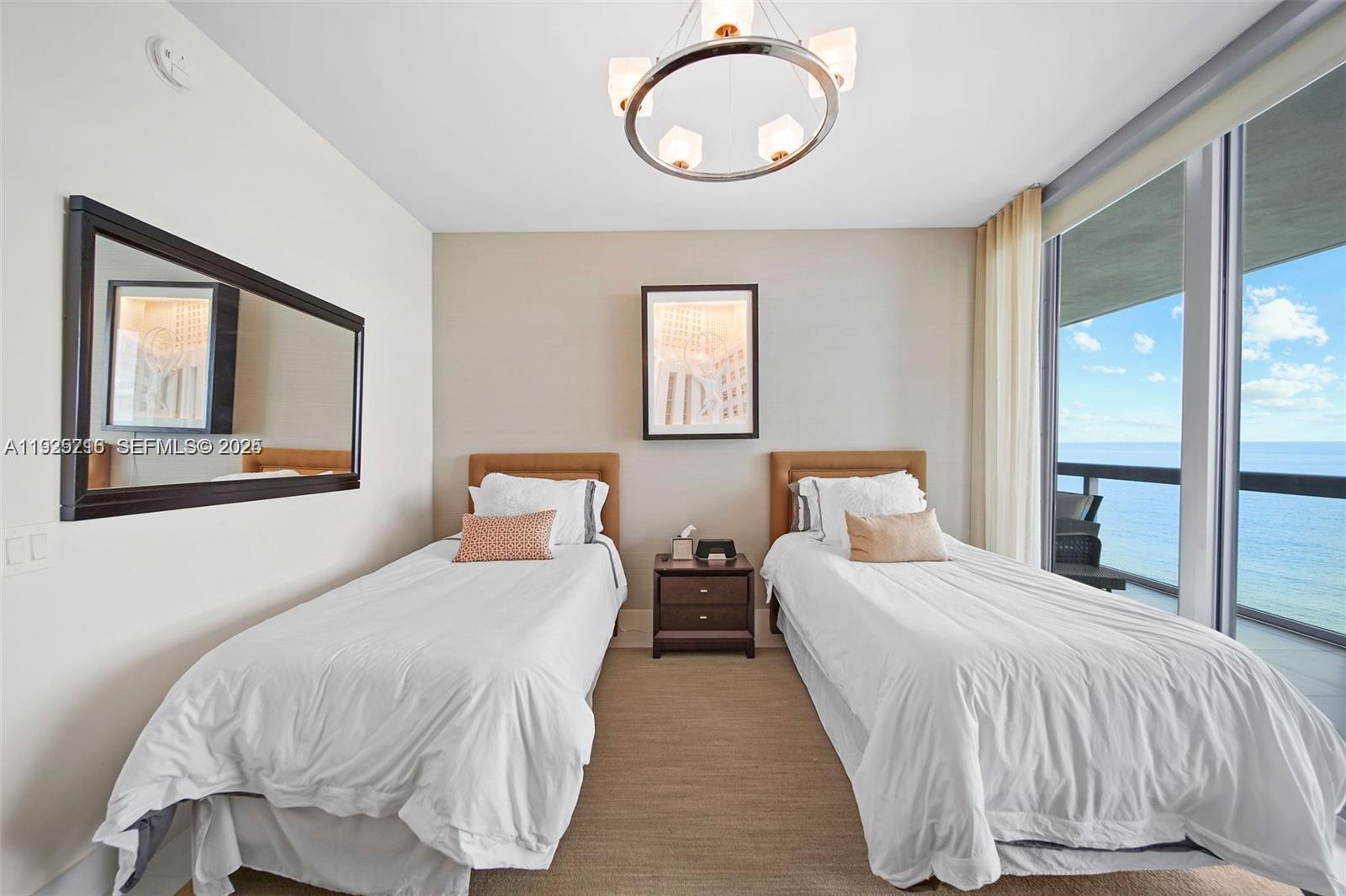 6899 Collins Avenue, Unit 1801 Miami Beach, FL 33141 - Photo 27 of 67 a bedroom with two beds and painting on the wall