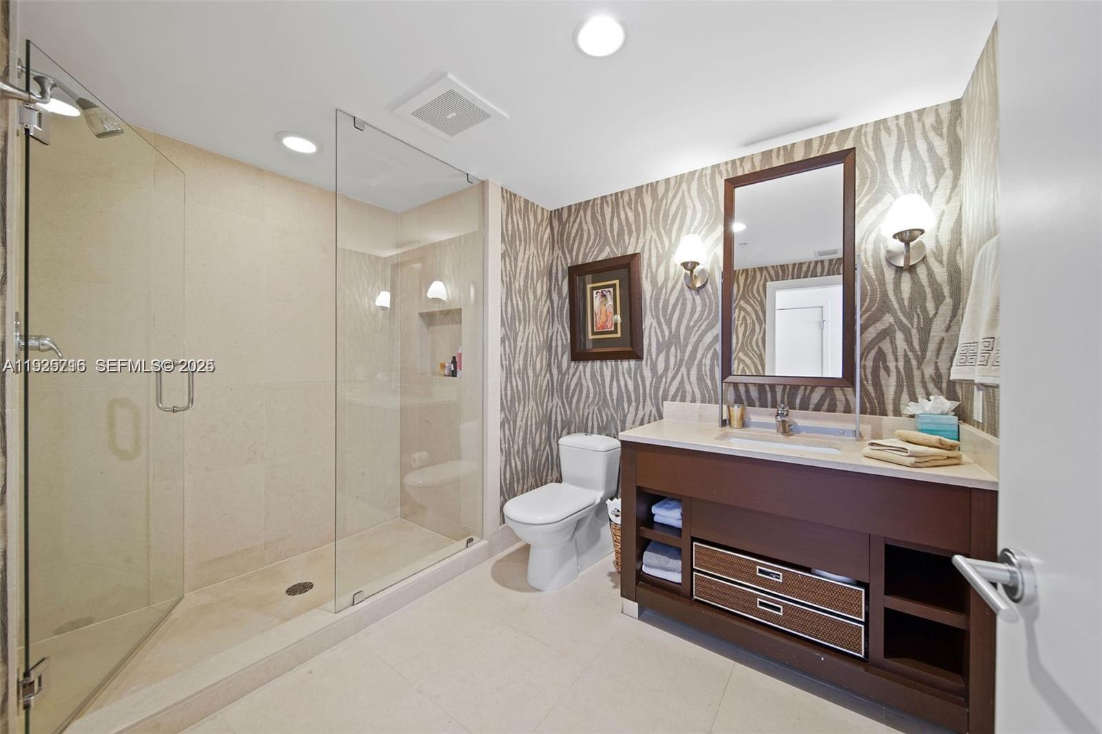 6899 Collins Avenue, Unit 1801 Miami Beach, FL 33141 - Photo 30 of 67 a bathroom with a double vanity sink toilet and shower
