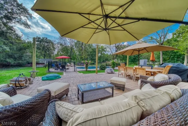 a view of a patio with a table and chairs under an umbrella