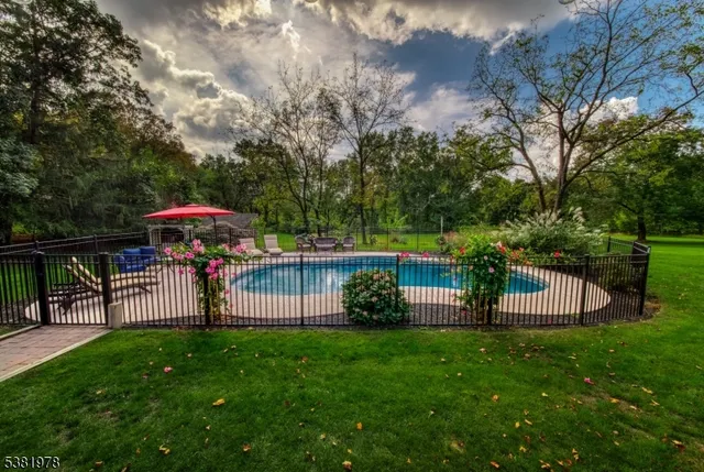 a view of a swimming pool with a table and chairs under an umbrella
