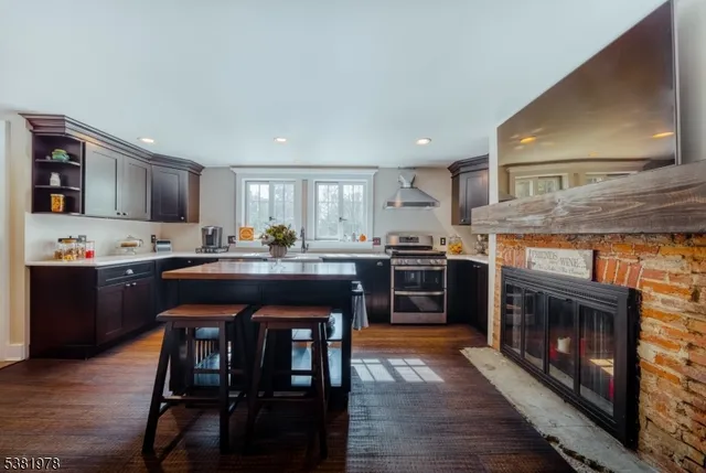 a kitchen with a sink a stove cabinets and wooden floor