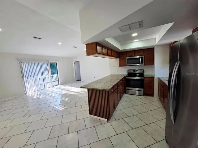 a kitchen with stainless steel appliances a refrigerator and a counter top space