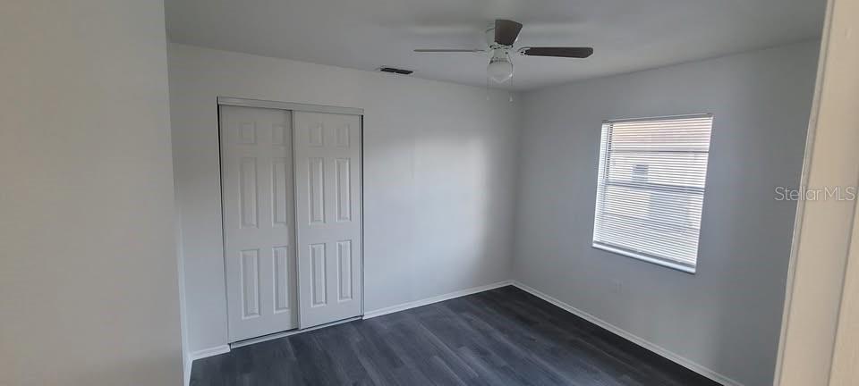 12200 Norvell Road Spring Hill, FL 34609 - Photo 4 of 16 a view of an empty room with a window and wooden floor
