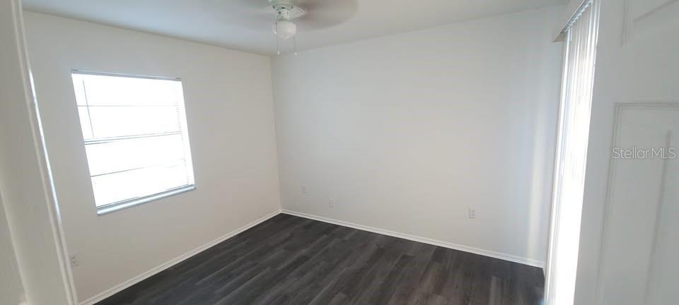 12200 Norvell Road Spring Hill, FL 34609 - Photo 6 of 16 an empty room with wooden floor and windows