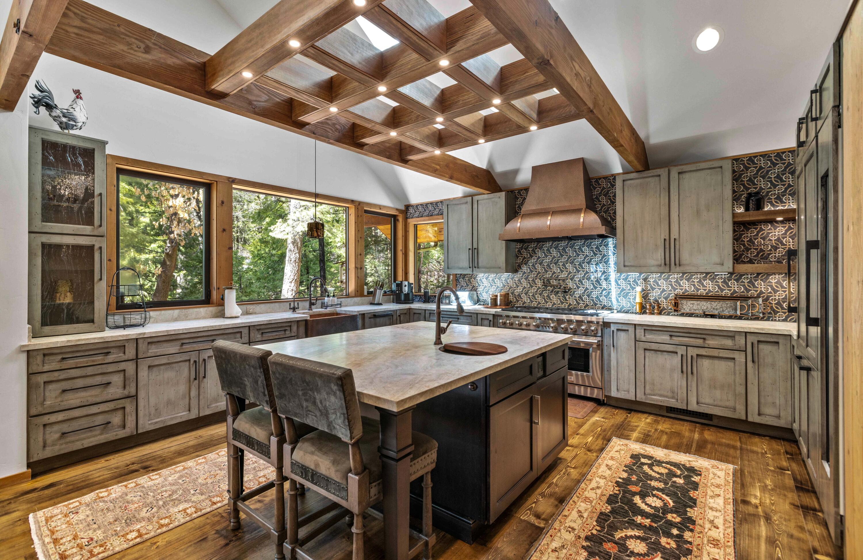 24581 Fern Valley Road Idyllwild, CA 92549 - Photo 15 of 45 a kitchen with stainless steel appliances granite countertop a sink a stove a dining table and chairs with wooden floor
