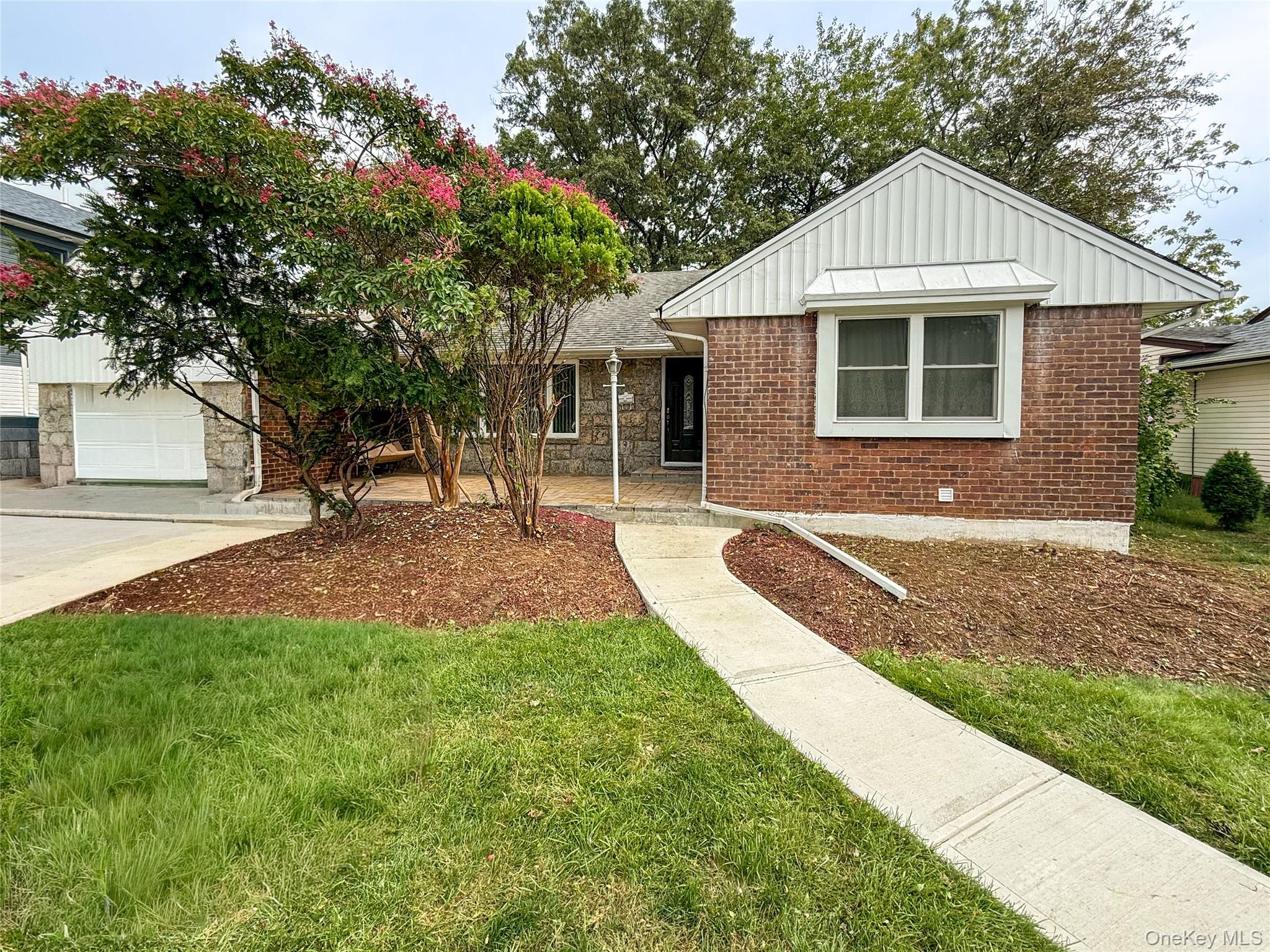 a front view of a house with a yard and potted plants