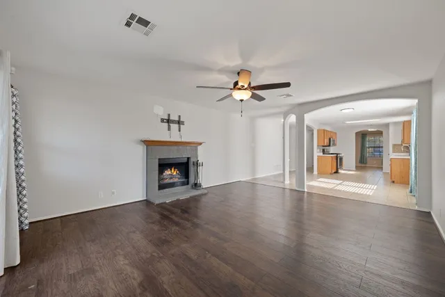 a view of an empty room with a window and wooden floor