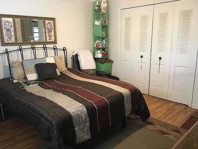 a bedroom with a bed and wooden floor