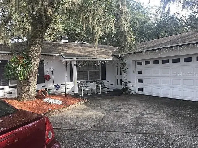 a view of a house with backyard and sitting area