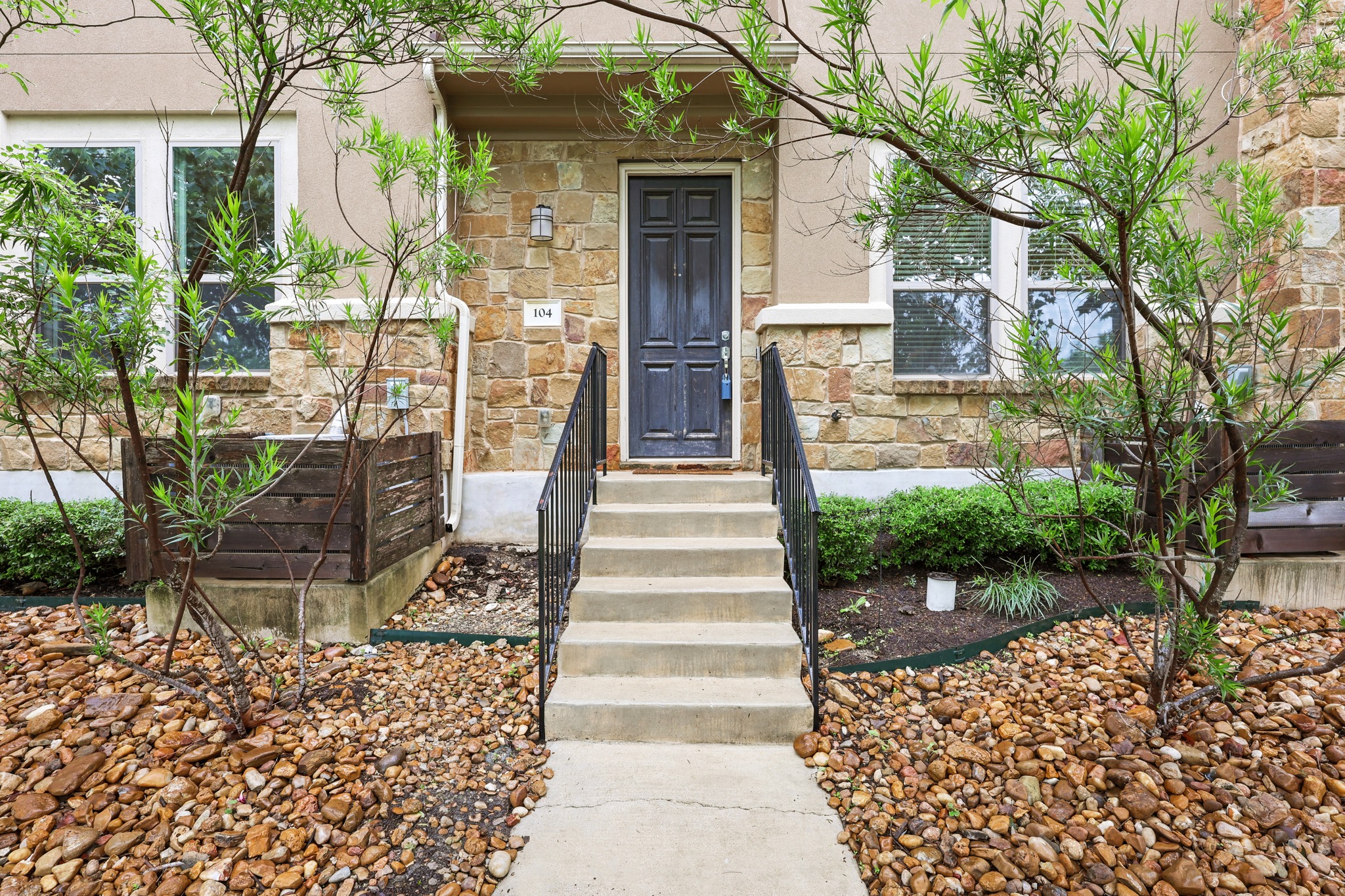 6814 East Riverside Drive, Unit 104 Austin, TX 78741 - Photo 7 of 37 a front view of a house with a garden and plants
