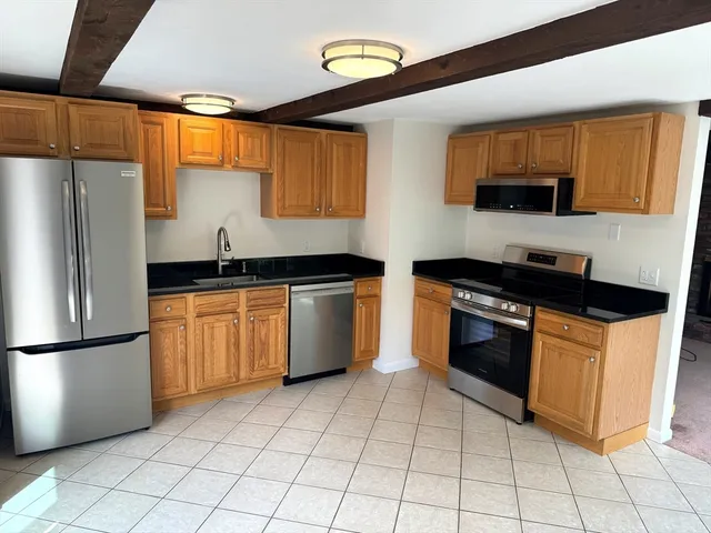 a kitchen with stainless steel appliances granite countertop a refrigerator and a stove top oven