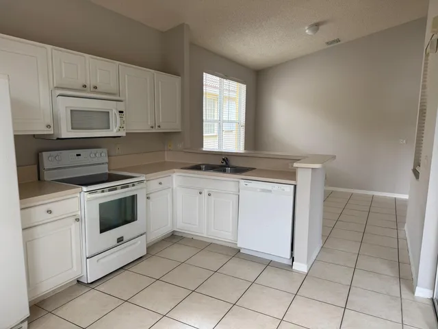 a kitchen with cabinets appliances and a window