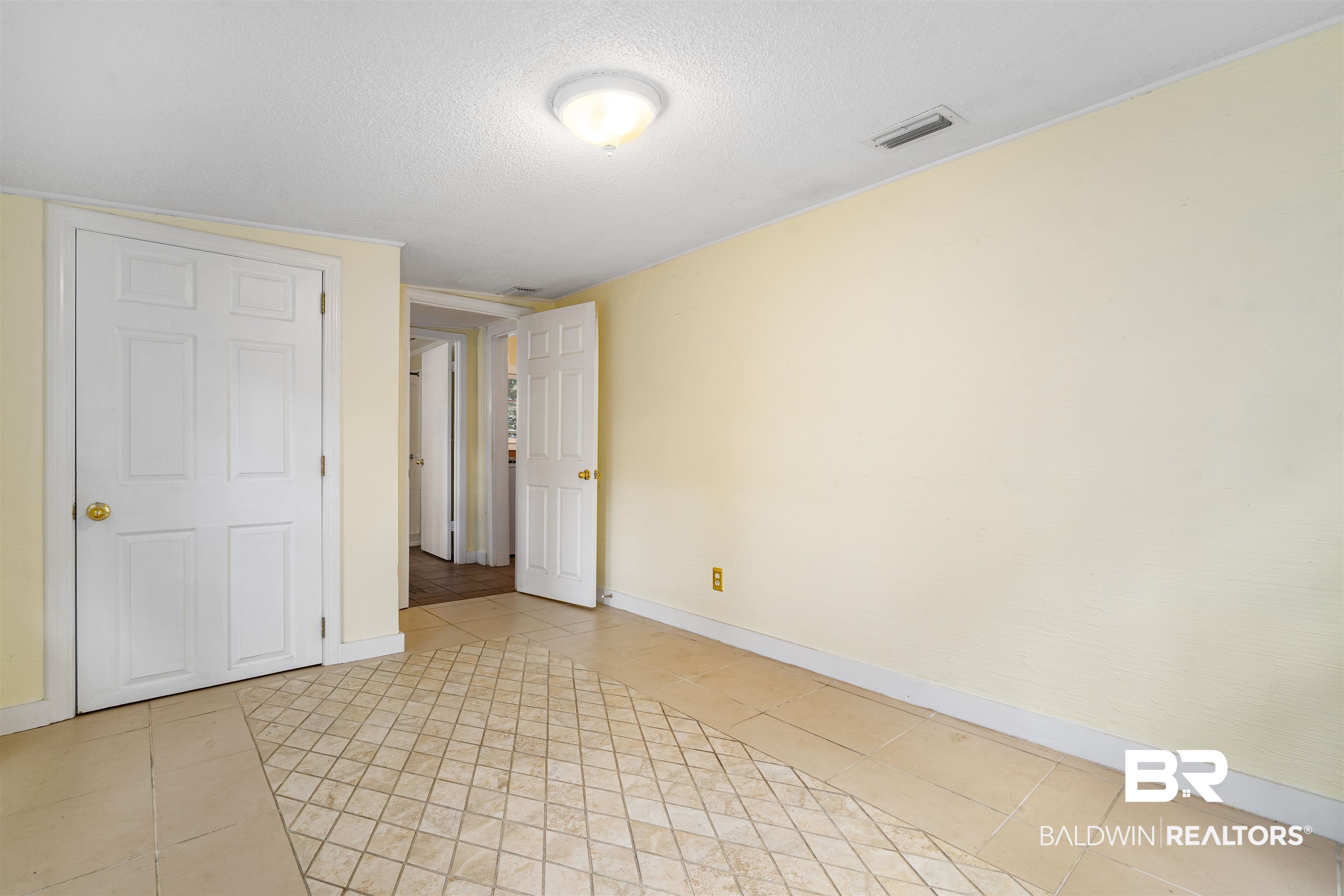 118 Mohawk Street Mobile, AL 36606 - Photo 19 of 26 Unfurnished bedroom featuring light tile patterned floors and a textured ceiling