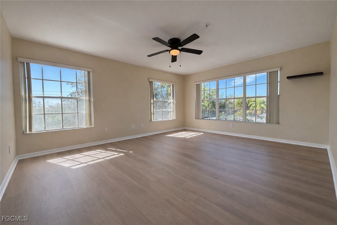 5390 Park Road, Unit 3 Fort Myers, FL 33908 - Photo 11 of 26 an empty room with wooden floor fan and windows
