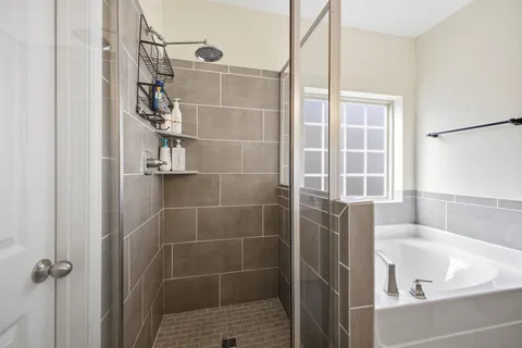 a white bath tub sitting next to a shower
