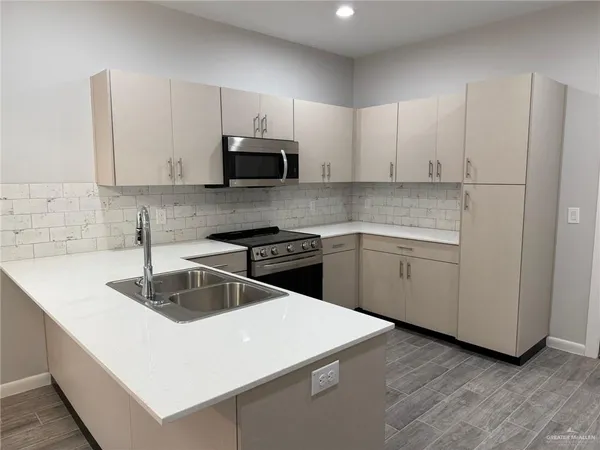 a large kitchen with stainless steel appliances granite countertop a stove and a sink