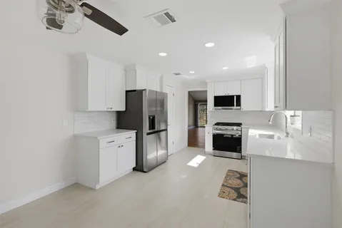a kitchen with stainless steel appliances a refrigerator sink and stove