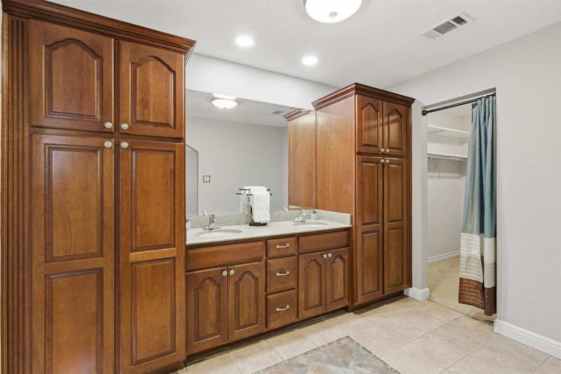 1600 East Messick Loop Round Rock, TX 78681 - Photo 25 of 38 The remodeled primary bathroom has beautiful wood cabinetry, pull out shelving and dual sinks.