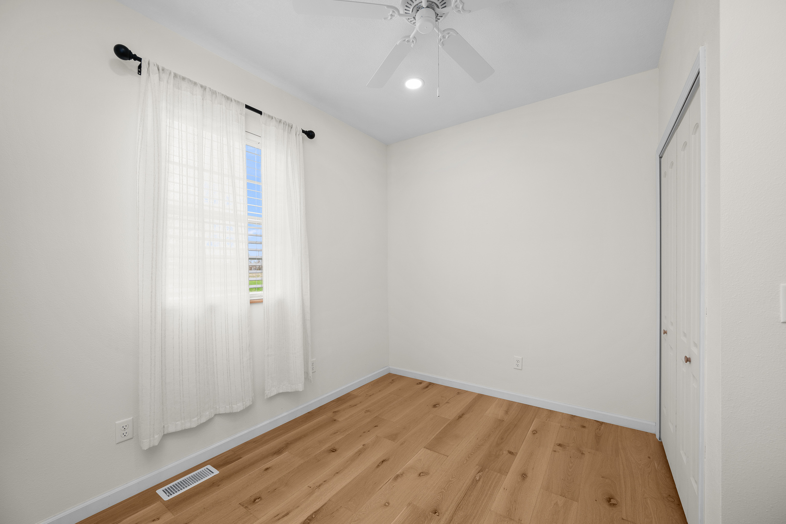 317 South Walnut Street Wilton, IA 52778 - Photo 13 of 45 a view of empty room with wooden floor and fan