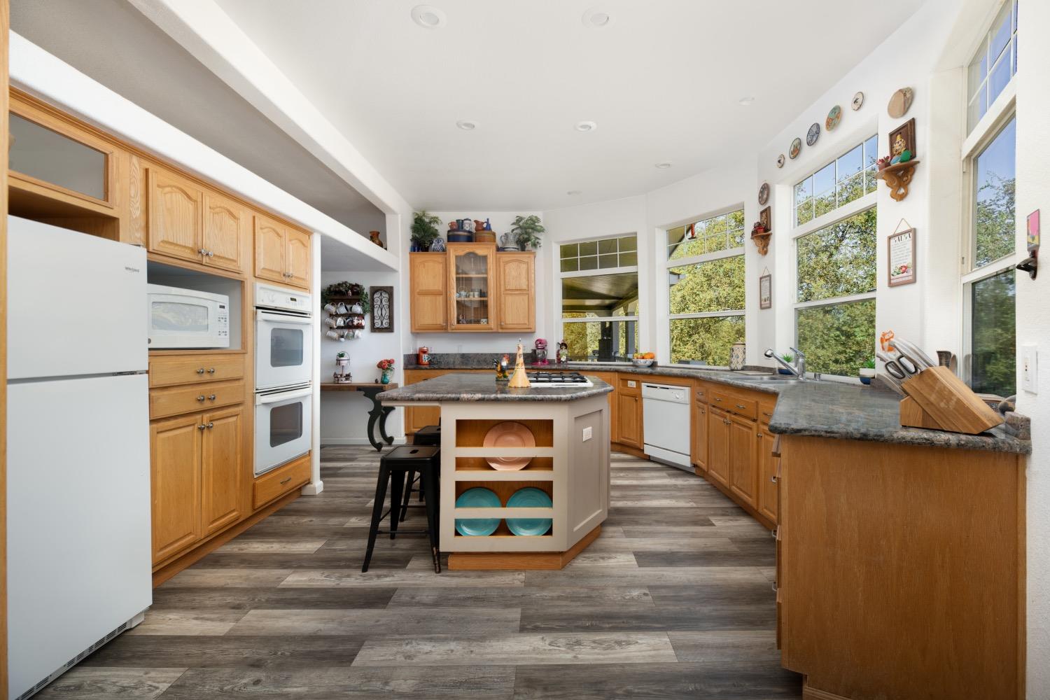 24090 Restive Way Grass Valley, CA 95949 - Photo 22 of 75 a kitchen with stainless steel appliances kitchen island granite countertop a refrigerator a stove and a wooden cabinets