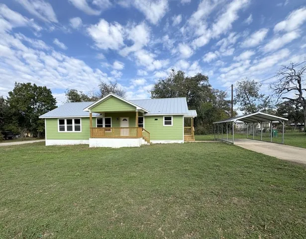 a front view of house with yard and green space