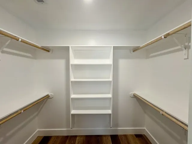 a view of walk in closet with empty racks