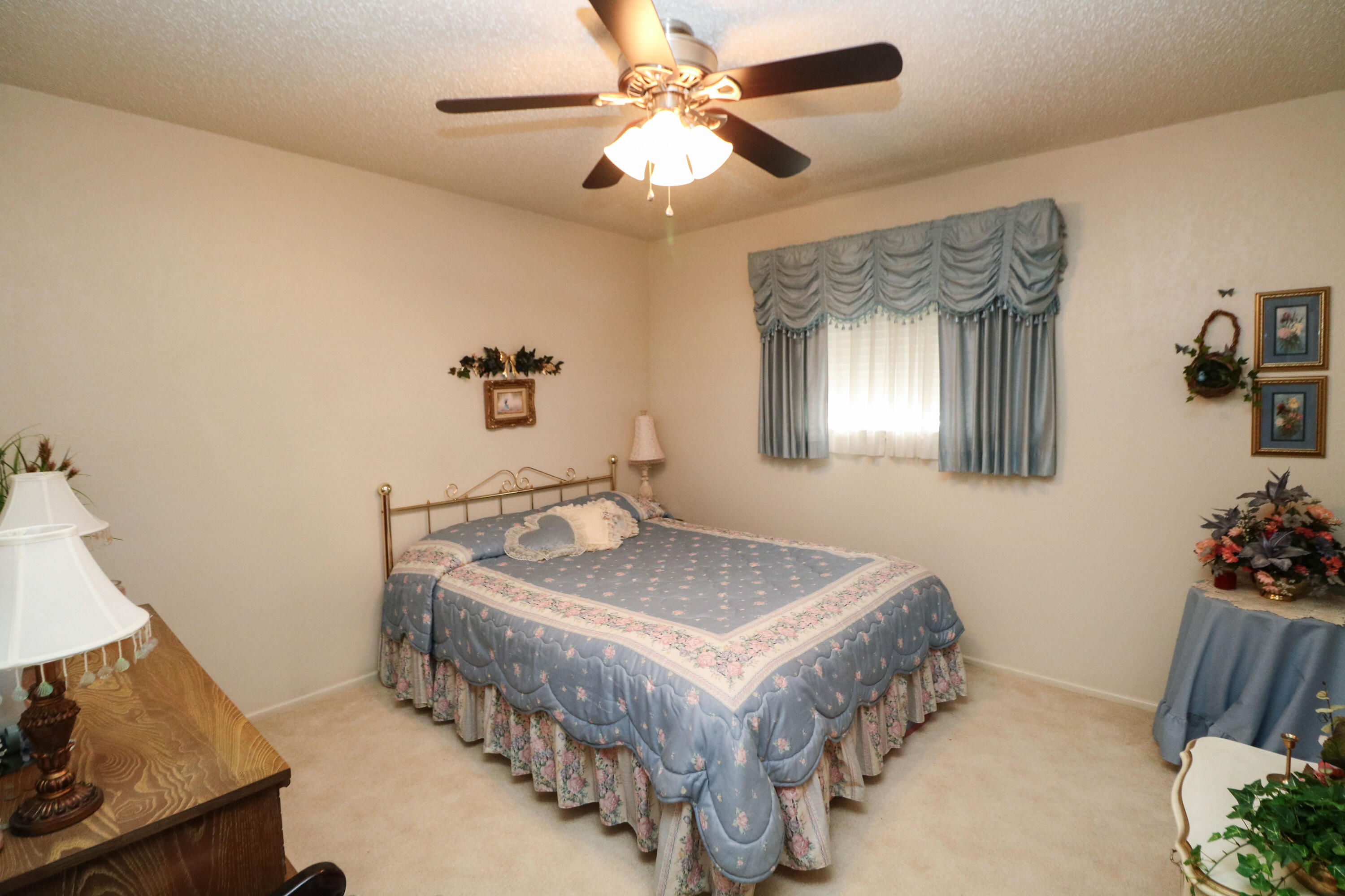 232 East 26th Street Littlefield, TX 79339 - Photo 16 of 26 a spacious bedroom with a bed and a chandelier