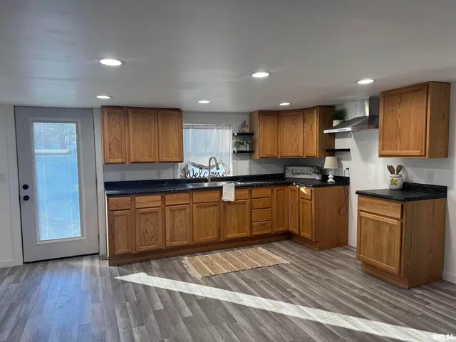 a kitchen with granite countertop wooden floors stainless steel appliances and cabinets