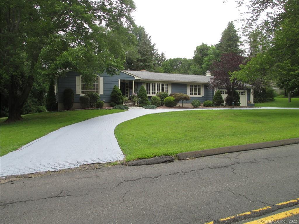 a front view of a house with a garden and trees