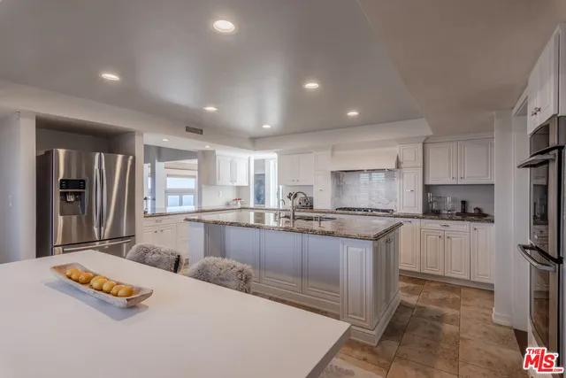a kitchen with center island a sink and living room view