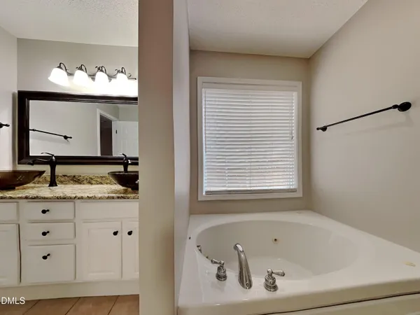 a bathroom with a granite countertop sink and a window