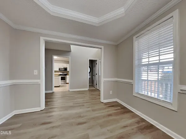 an empty room with wooden floor closet and windows