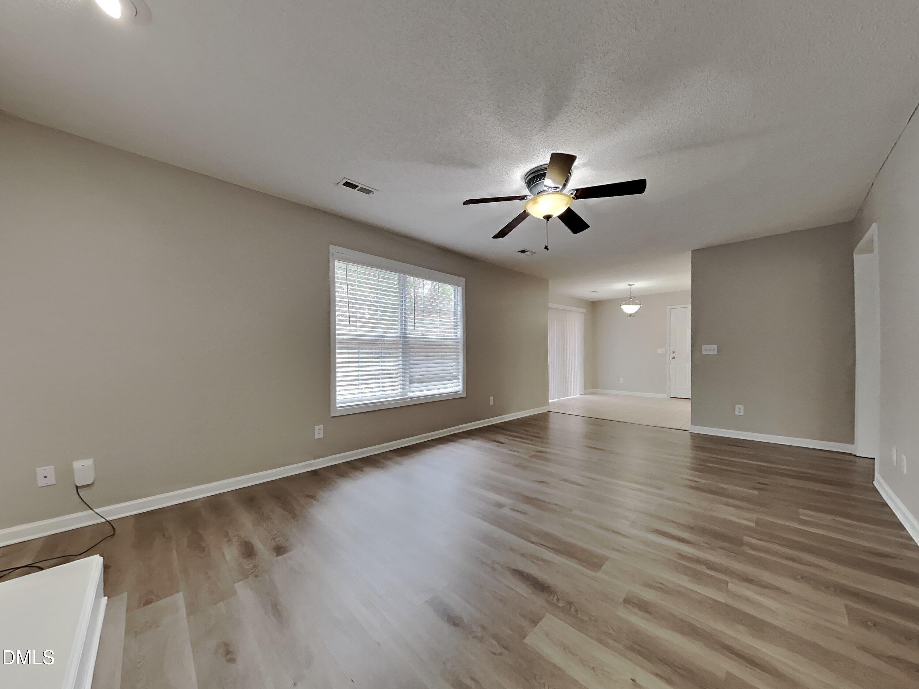 226 Linden Road Cameron, NC 28326 - Photo 2 of 20 an empty room with wooden floor ceiling fan and window