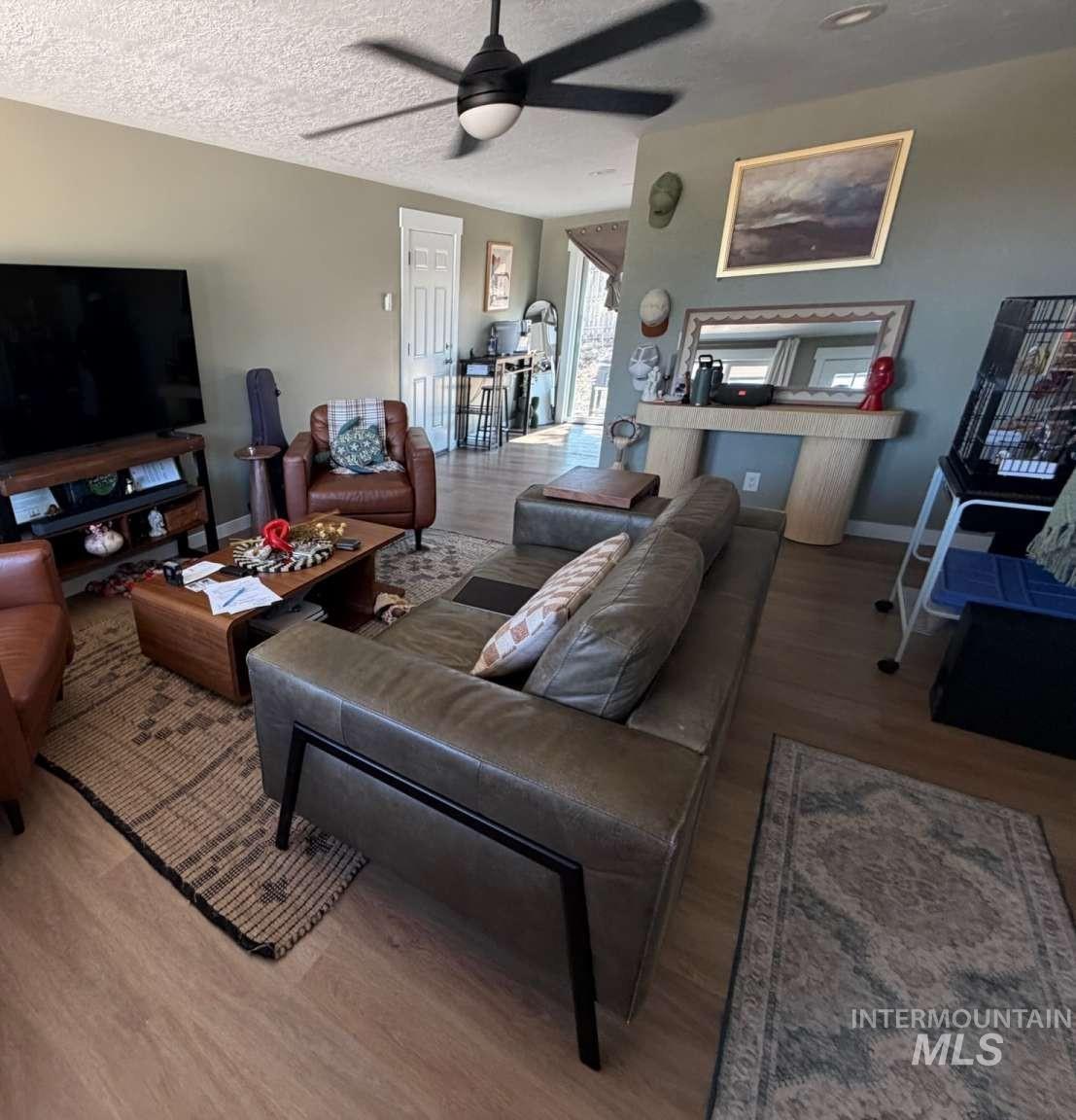 9951 West Fox Ridge Drive Boise, ID 83709 - Photo 13 of 13 Living area featuring wood-finish flooring, a contemporary ceiling fan, and light neutral wall colors