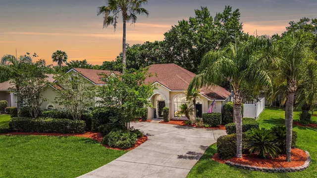 a front view of a house with a yard and potted plants
