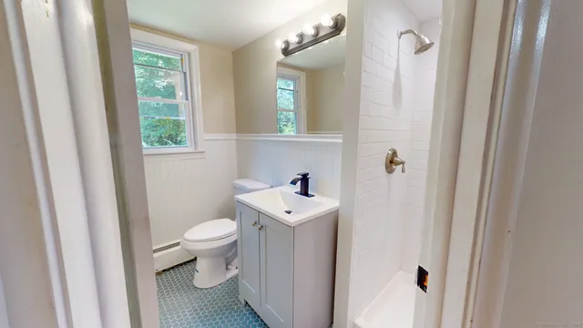 a bathroom with a sink a toilet and a mirror