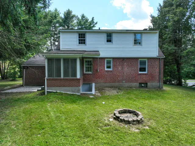 a backyard of a house with potted plants and large tree