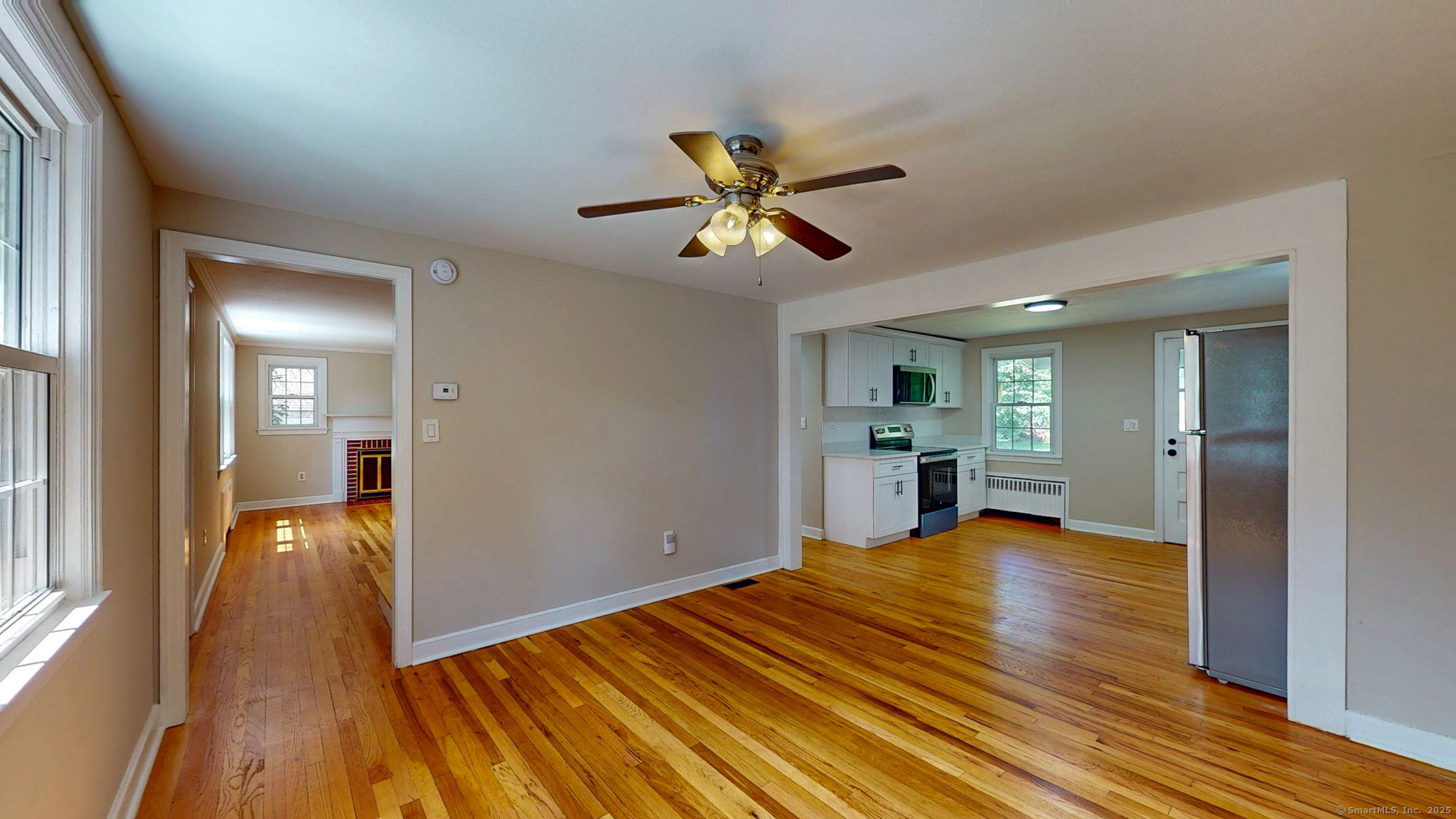 86 Gabb Road Bloomfield, CT 06002 - Photo 4 of 40 a view of a room with wooden floor a ceiling fan and a kitchen