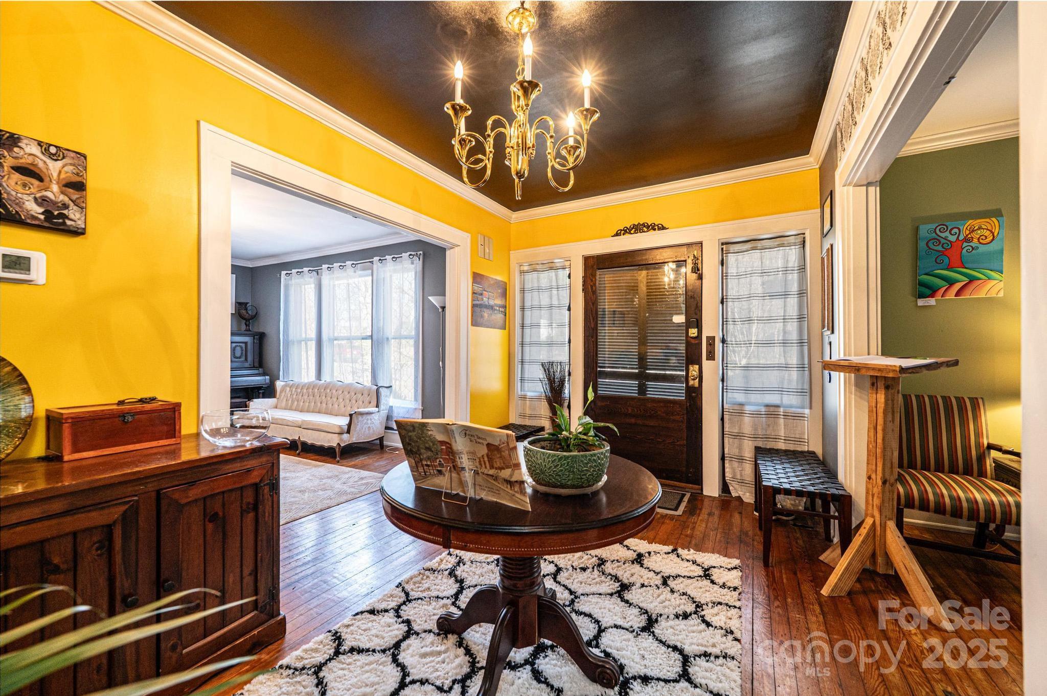 221 3rd Street Northeast Hickory, NC 28601 - Photo 4 of 40 a living room with furniture a chandelier and a floor to ceiling window