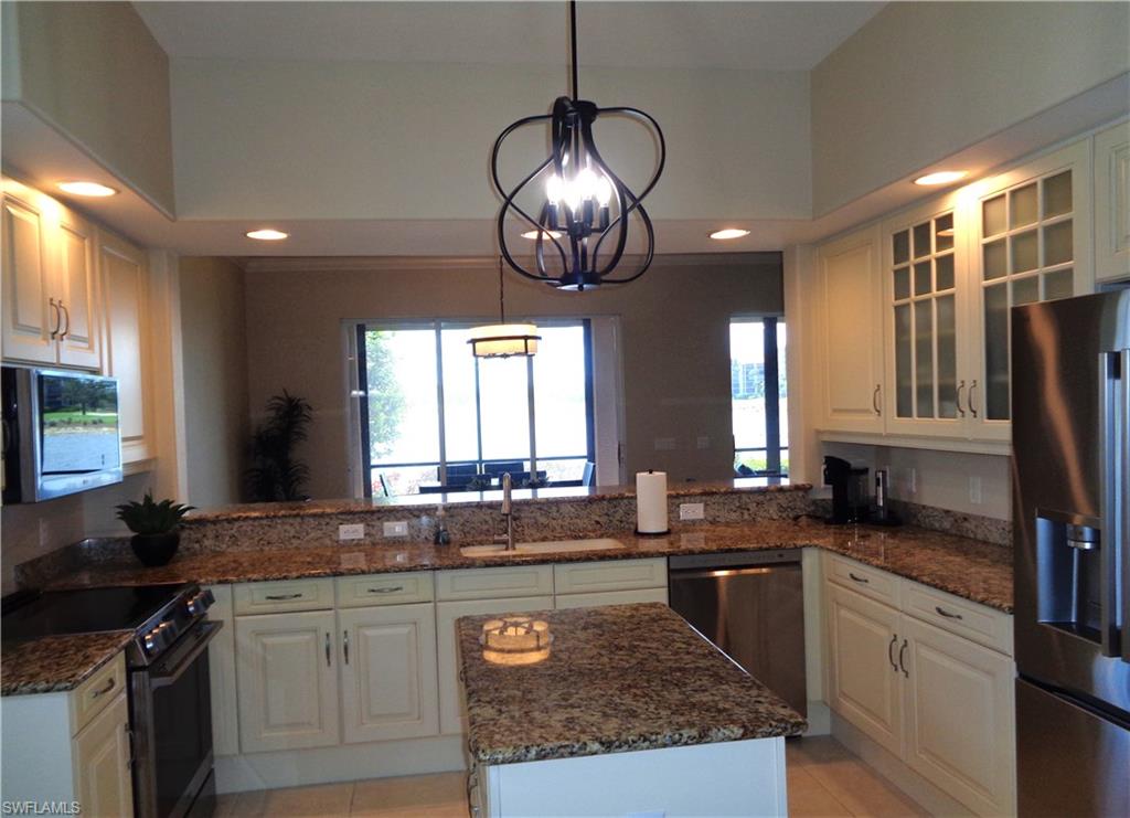 734 Regency Reserve Circle, Unit 2701 Naples, FL 34119 - Photo 11 of 37 a kitchen with stainless steel appliances granite countertop a sink stove and cabinets
