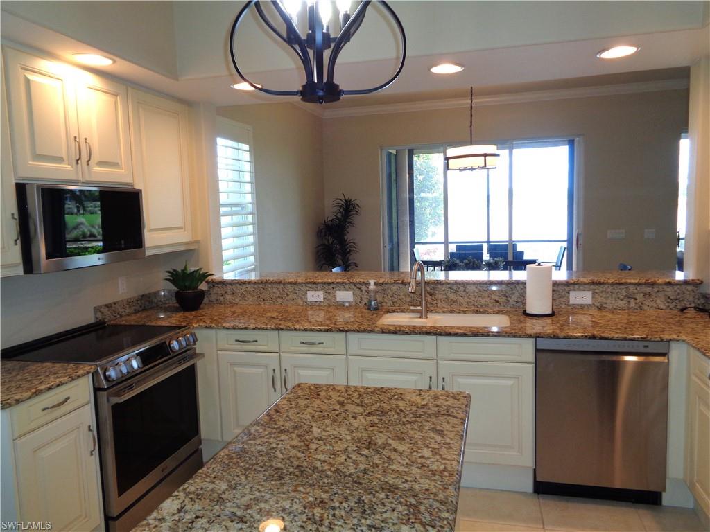 734 Regency Reserve Circle, Unit 2701 Naples, FL 34119 - Photo 12 of 37 a kitchen with a sink stove and cabinets