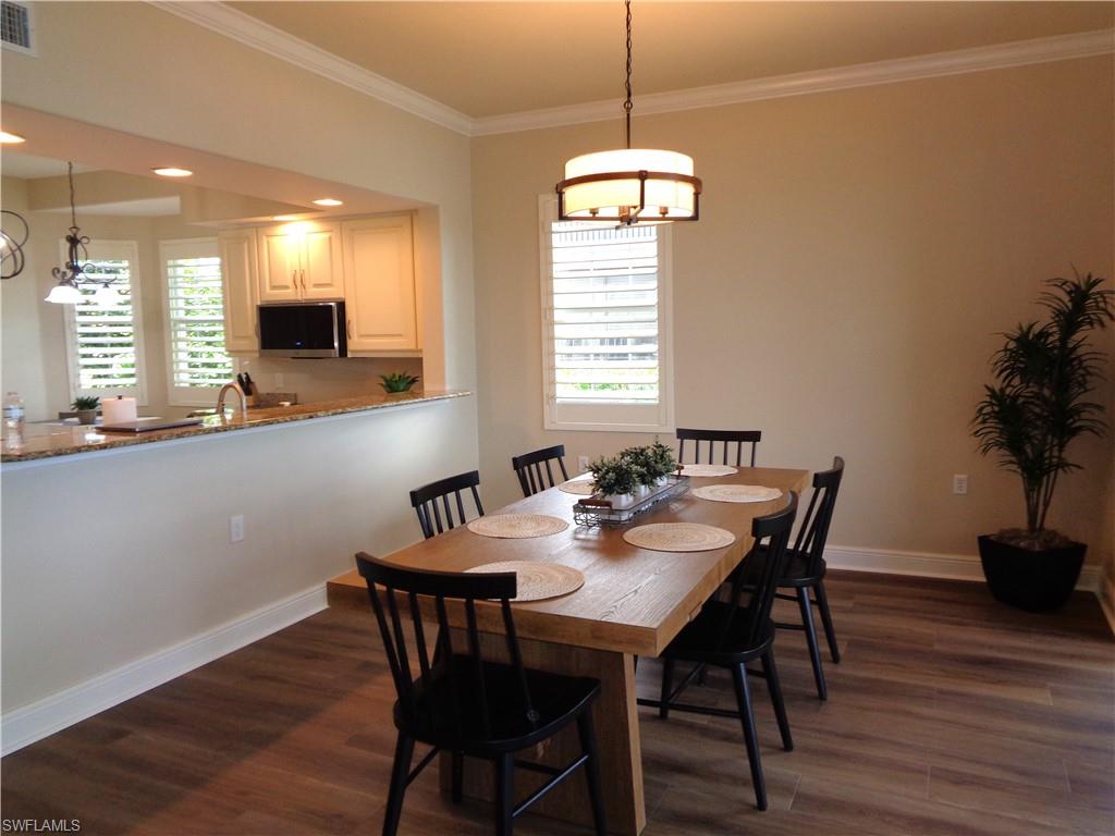 734 Regency Reserve Circle, Unit 2701 Naples, FL 34119 - Photo 16 of 37 a view of a dining room with furniture window and wooden floor
