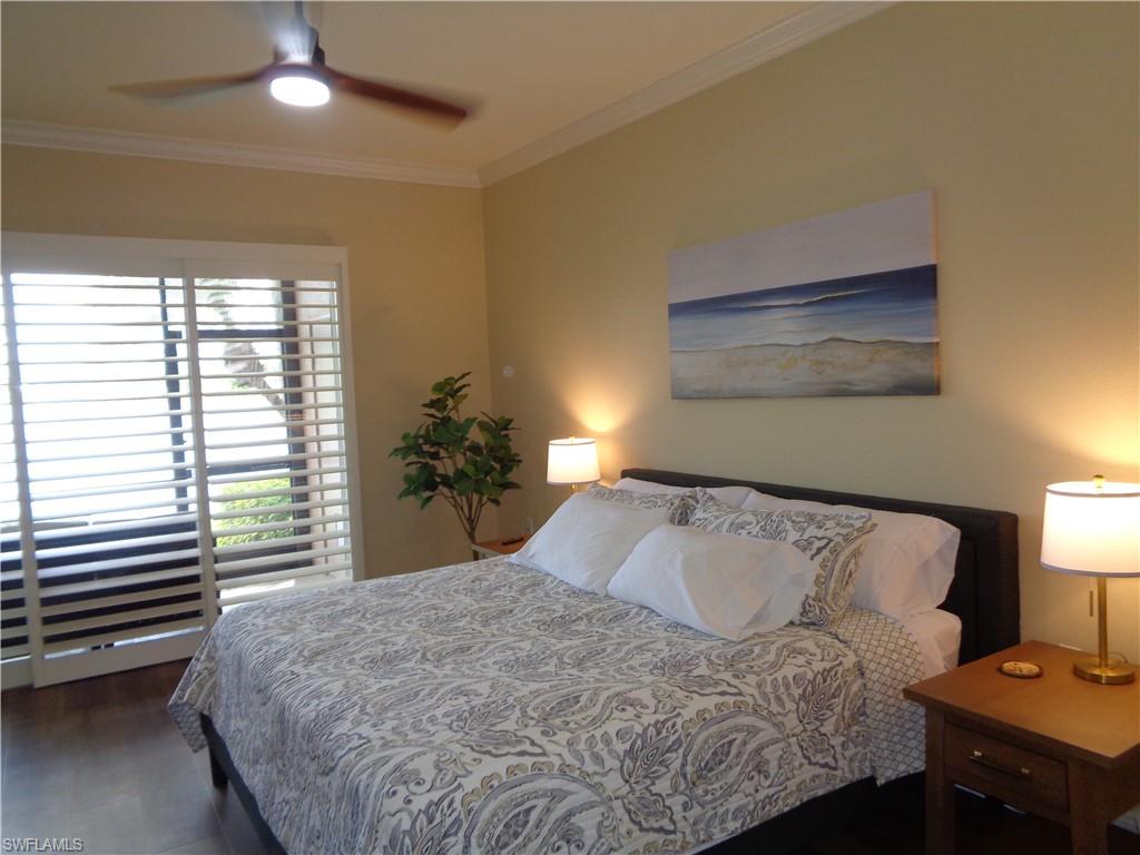 734 Regency Reserve Circle, Unit 2701 Naples, FL 34119 - Photo 19 of 37 a bedroom with a bed and a lamp