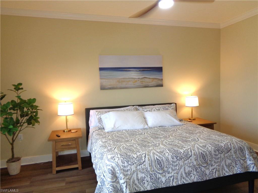 734 Regency Reserve Circle, Unit 2701 Naples, FL 34119 - Photo 20 of 37 a bedroom with a bed and a lamp