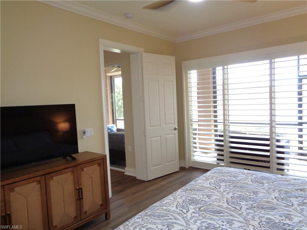 734 Regency Reserve Circle, Unit 2701 Naples, FL 34119 - Photo 21 of 37 a living room with flat screen tv and wooden floor
