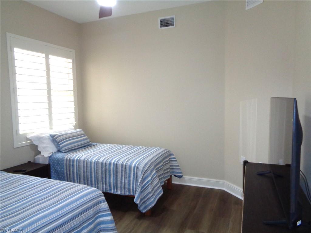 734 Regency Reserve Circle, Unit 2701 Naples, FL 34119 - Photo 25 of 37 a bedroom with two beds and a flat screen tv