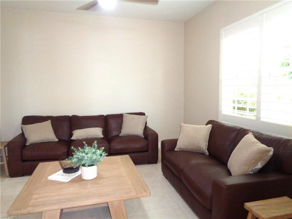 734 Regency Reserve Circle, Unit 2701 Naples, FL 34119 - Photo 5 of 37 a living room with furniture and a potted plant